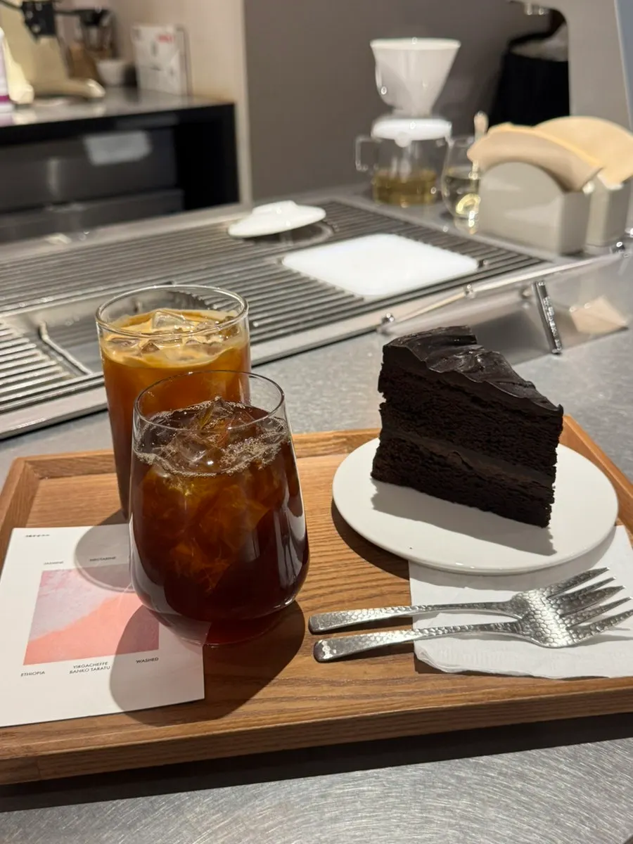 Americano đá decaf trên bàn có hoa tươi