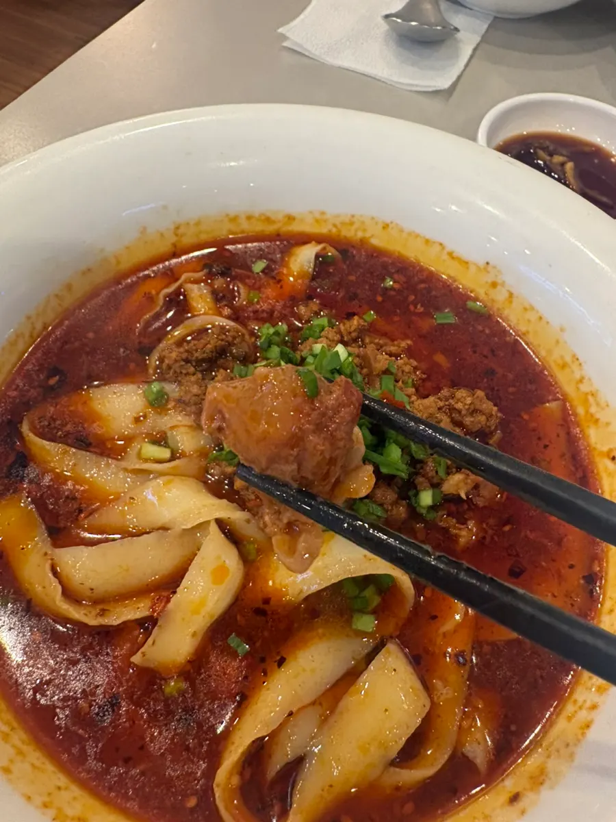 Potongan daging sapi besar dan dosakmyeon di dalam kuah merah