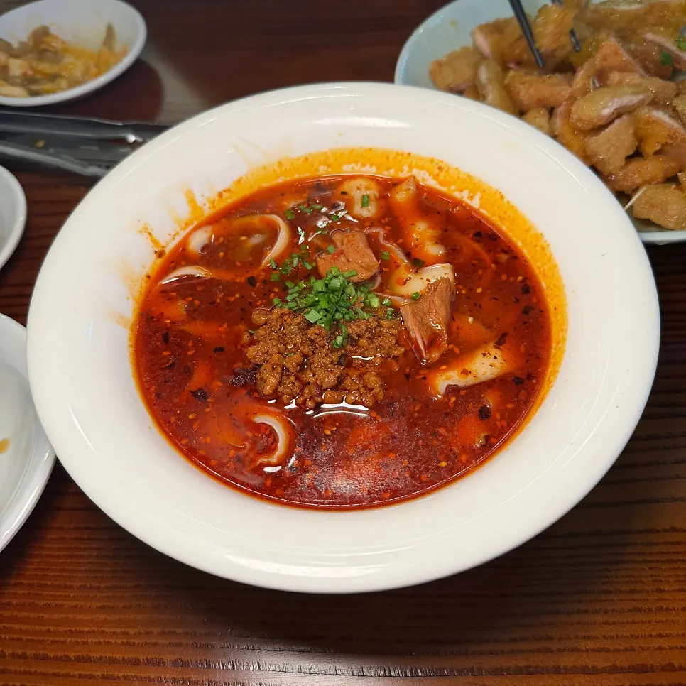 Sichuan-style beef knife-cut noodles with chili oil floating on top