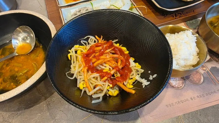A bowl of bibimbap with vegetable dishes