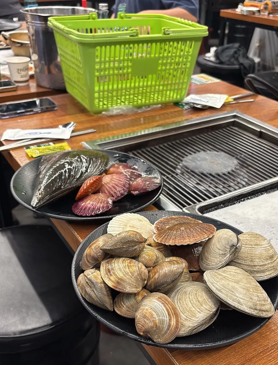 Two plates piled high with a variety of shellfish