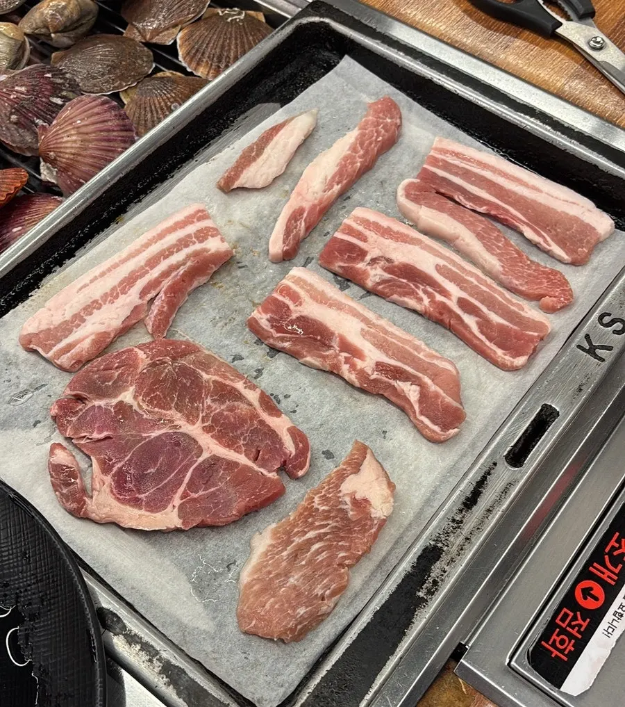 Golden, crispy pork belly and kimchi cooking on the grill