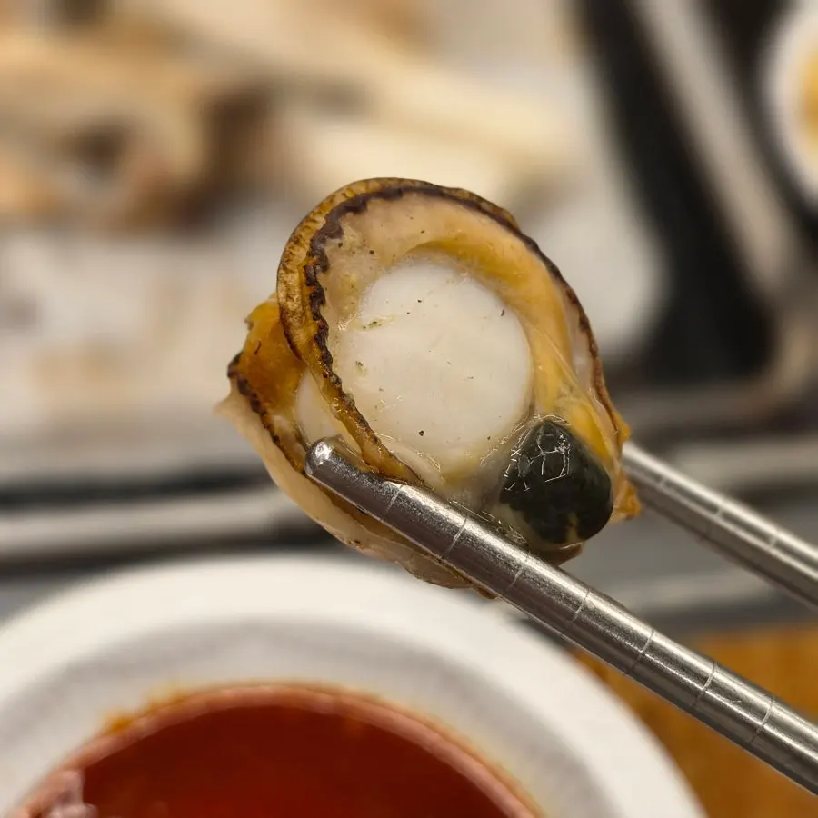 Open shellfish and golden-brown meat on the grill