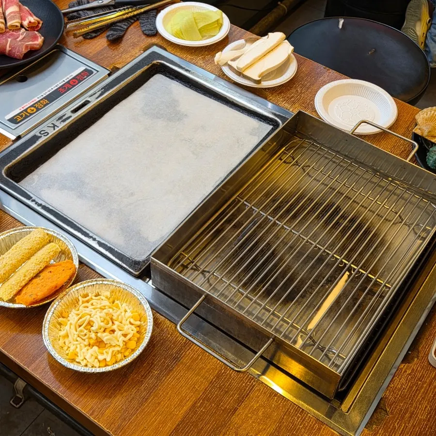 고기 불판과 조개 찜판이 따로 놓인 테이블