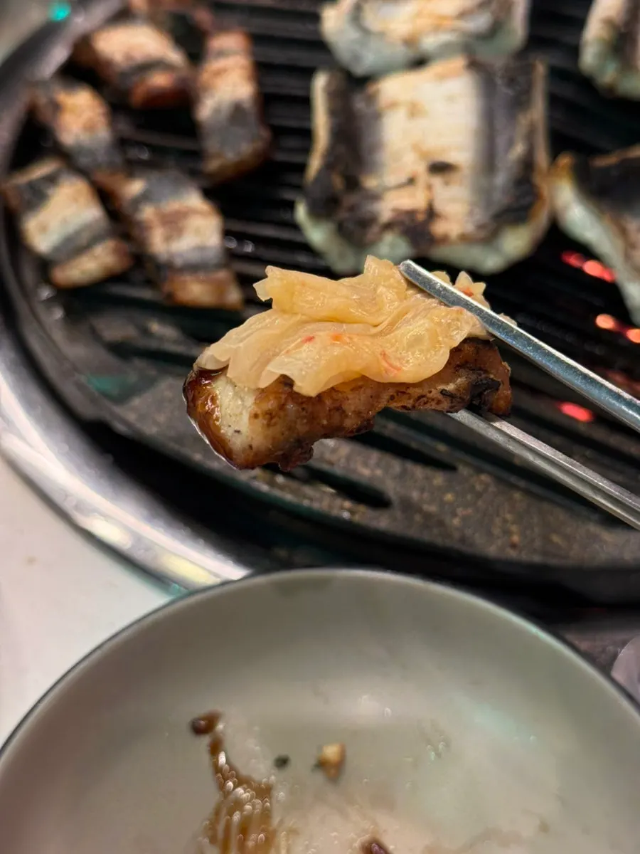 백김치를 올려 소스에 찍어 먹는 장어