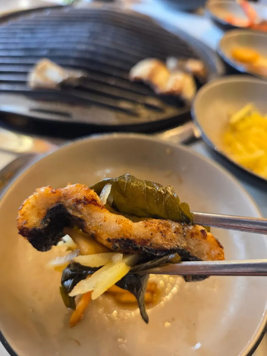 A plate of grilled meat served alongside the eel