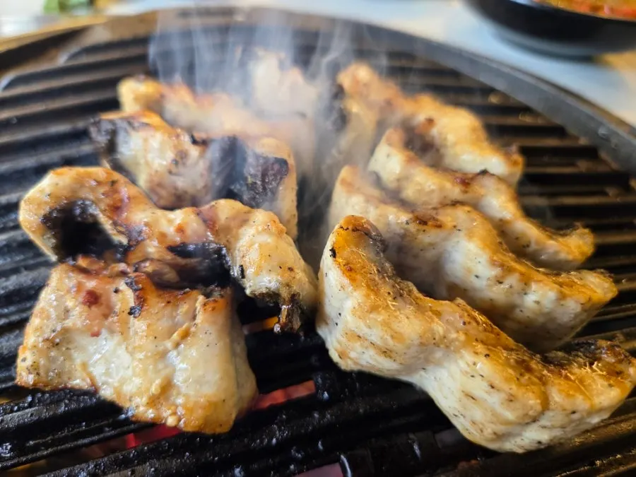 Eel cooking alongside green onion kimchi