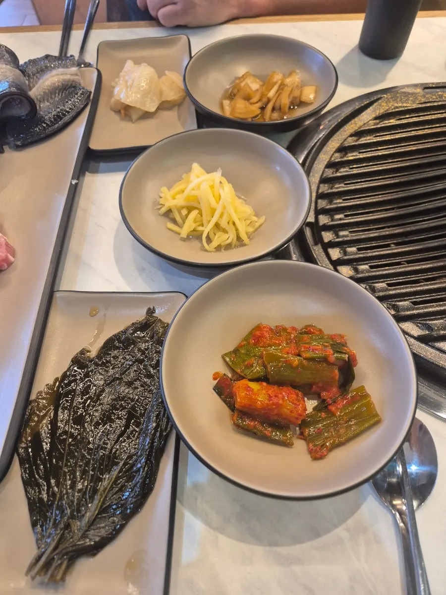 Table set with pickled perilla leaves, green onion kimchi, and other basic side dishes
