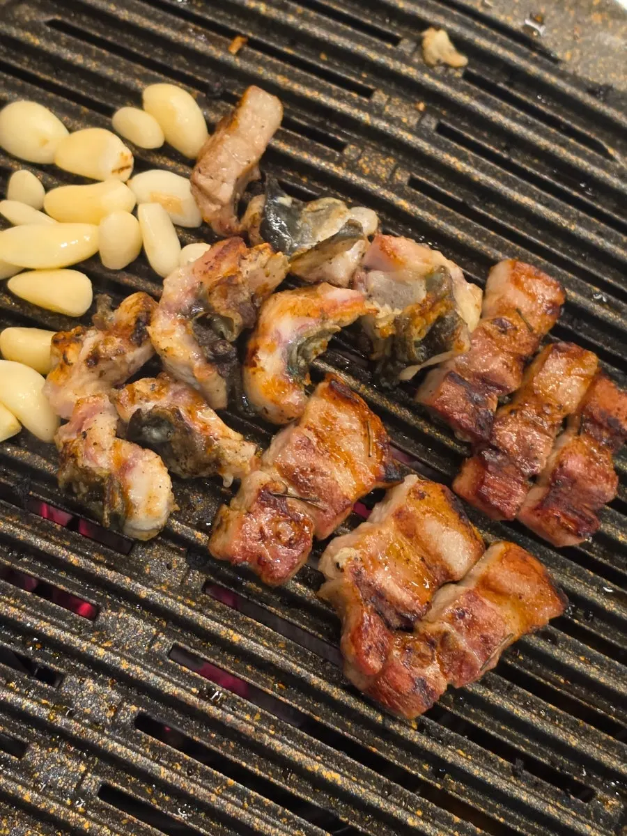 Grill pan with eel and meat near the end of the meal