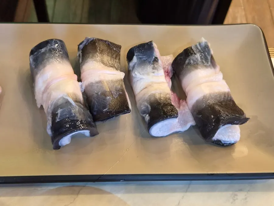 Grilled eel topped with sauce and ginger slivers