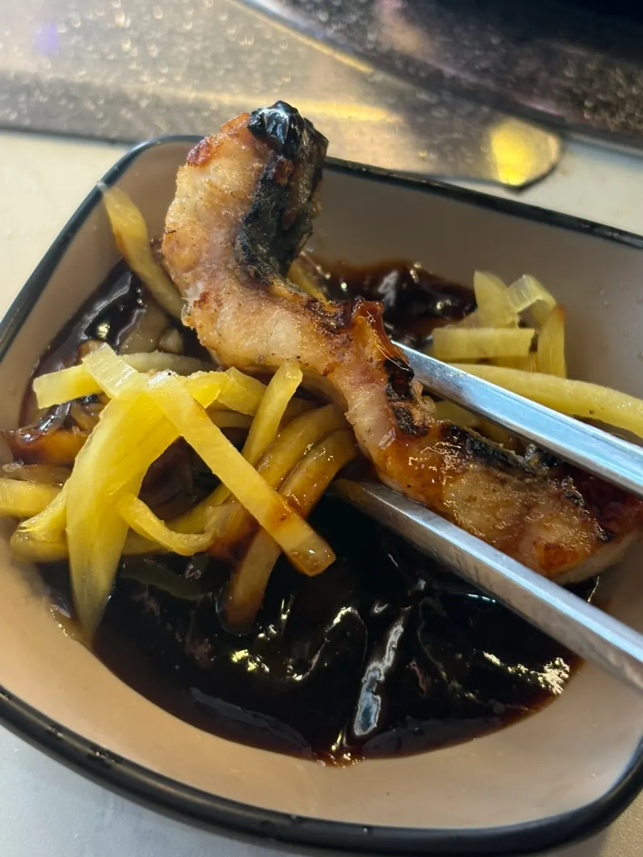 A bite of pork belly wrapped in perilla leaf