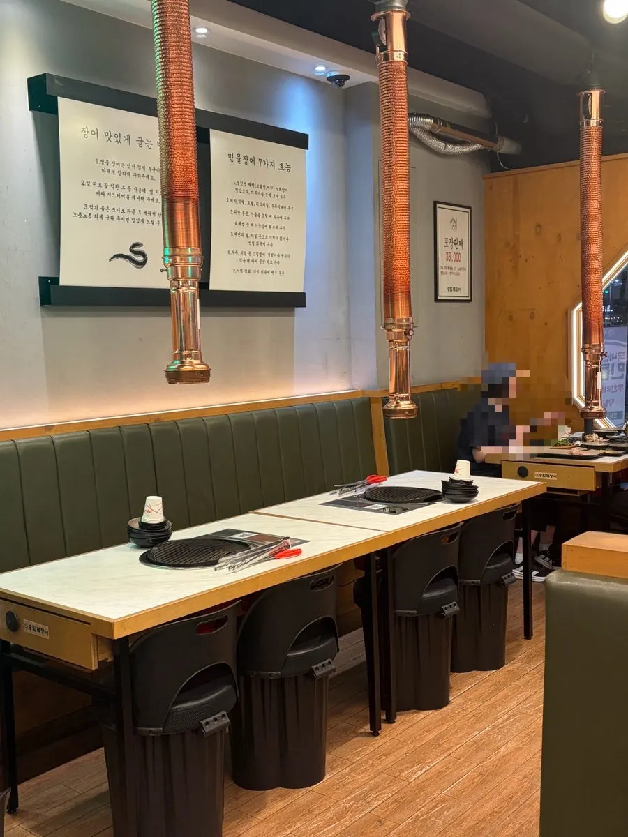 Restaurant interior with a grill and hood at every table