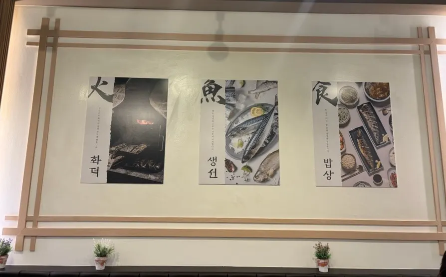 Wall photos depicting the wood-fired oven, fish, and table settings