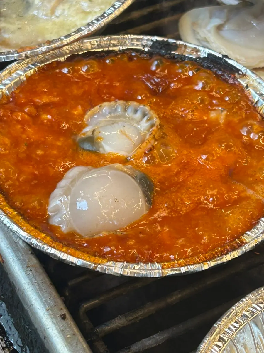 Geoduck and clams cooking on the grill