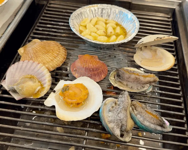 Unlimited grilled shellfish and pork belly spread
