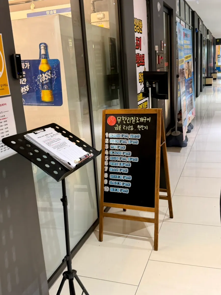 Gran cartel de Unlimited Refill Grilled Shellfish en el exterior del edificio