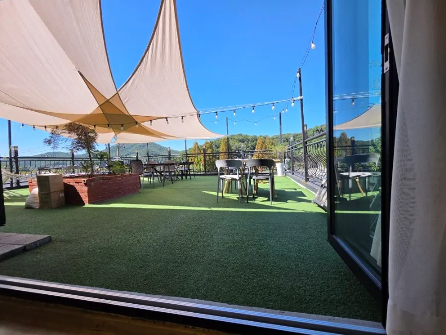 Terrace with shade canopy, tables, and mountain view