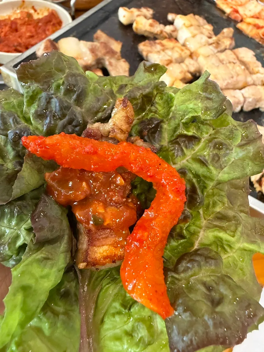 A piece of samgyeopsal topped with grilled doenjang