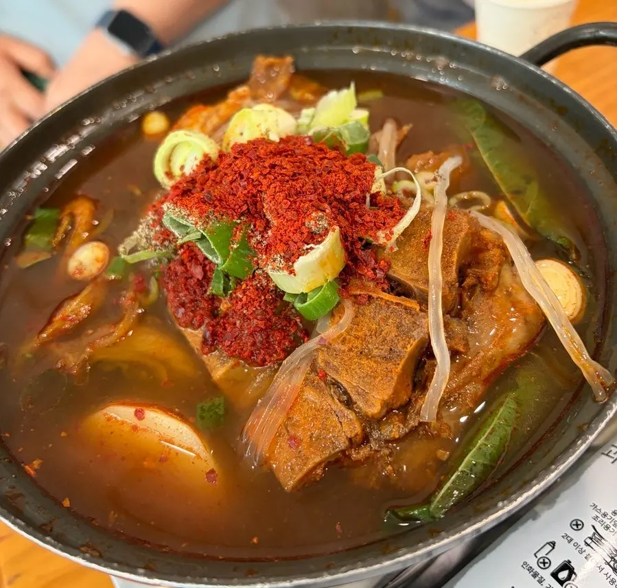 Side dishes including scallion salad, bossam kimchi, and spicy oyster jeotgal