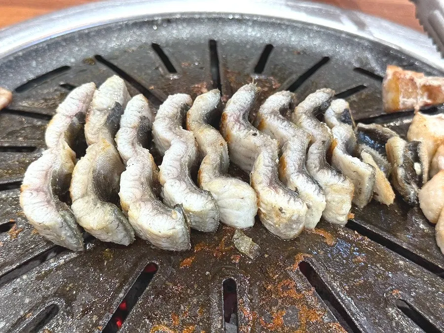 Eel being grilled after having its fin trimmed