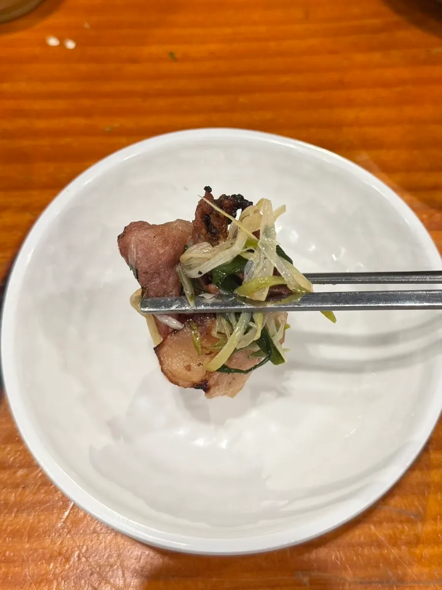 Bulgogi and scallions being dipped in special sauce