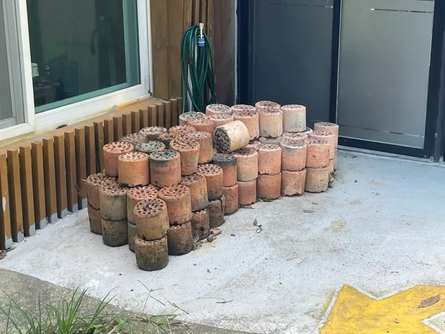Used charcoal briquettes stacked behind the restaurant