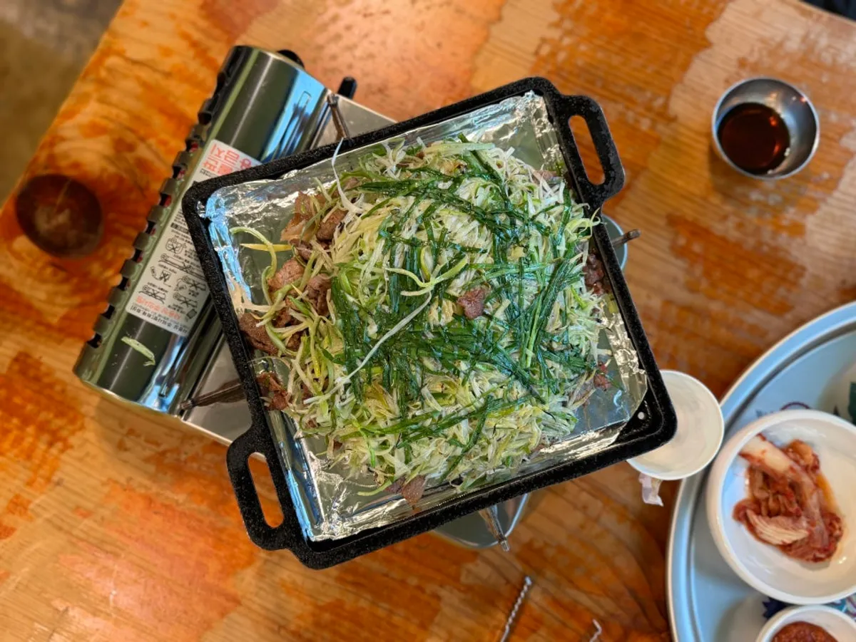 A full table spread of Bulhyangjip's charcoal scallion bulgogi