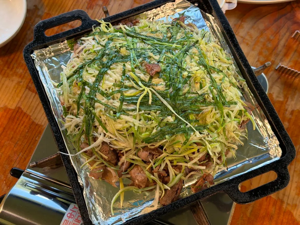 Three servings of charcoal scallion bulgogi piled with shredded scallions