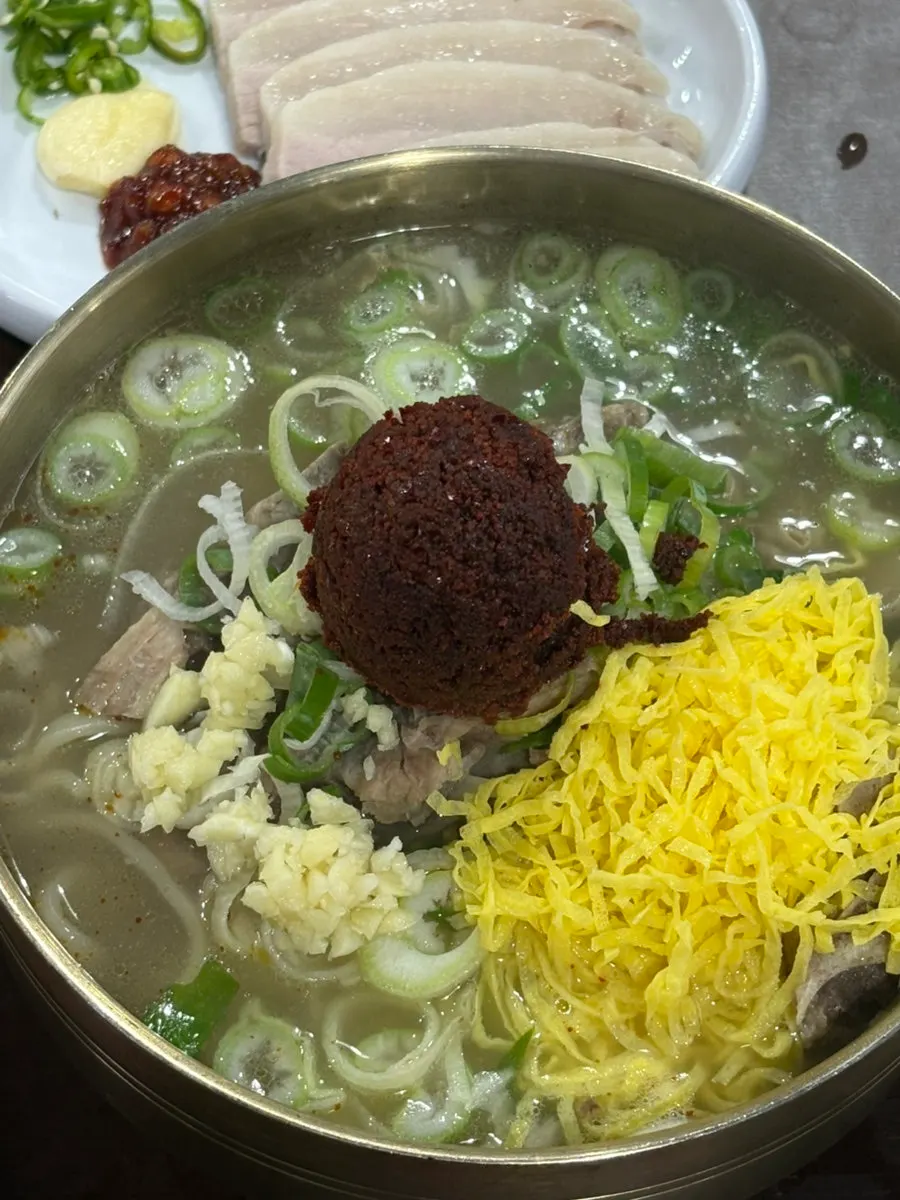 A bowl of bone kalguksu before the seasoning paste is stirred in