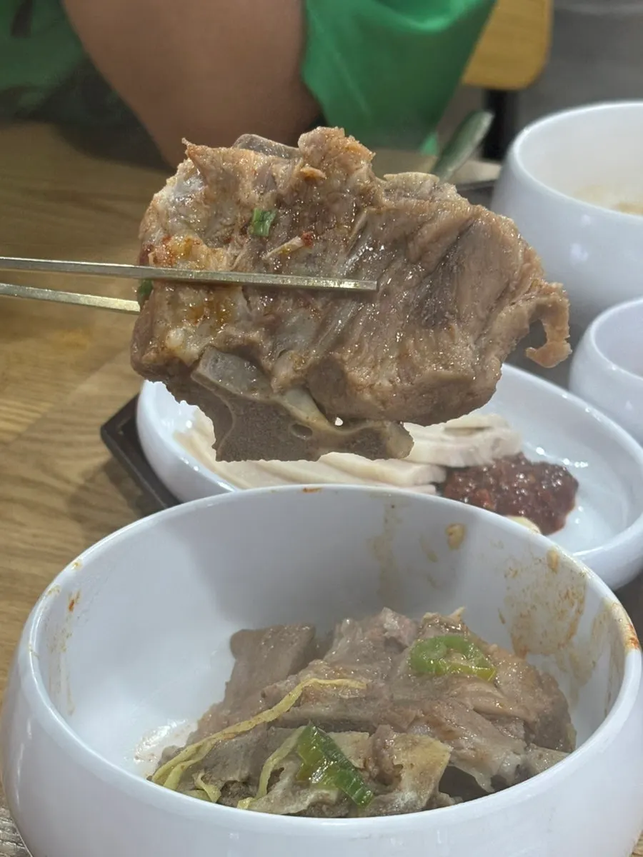 Reddened spicy bone kalguksu broth after mixing in the seasoning paste