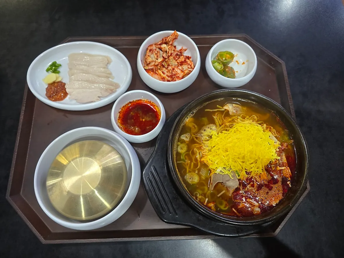 Bone kalguksu with egg garnish served with suyuk, kimchi salad, and rice