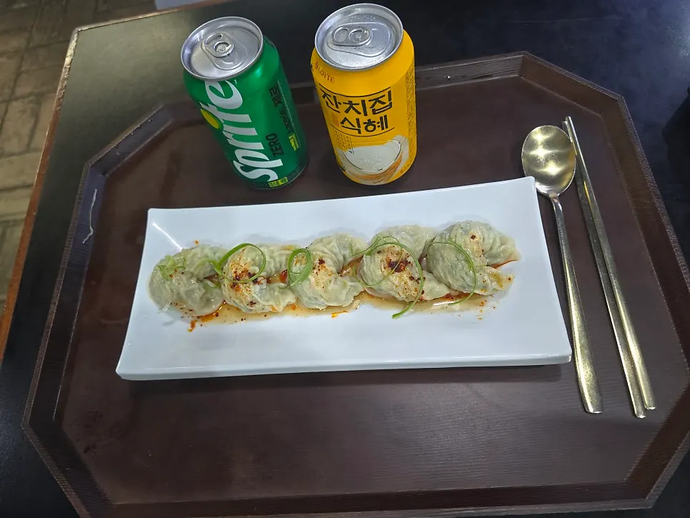 Five meat dumplings topped with scallions and seasoning sauce, with cider and sikhye