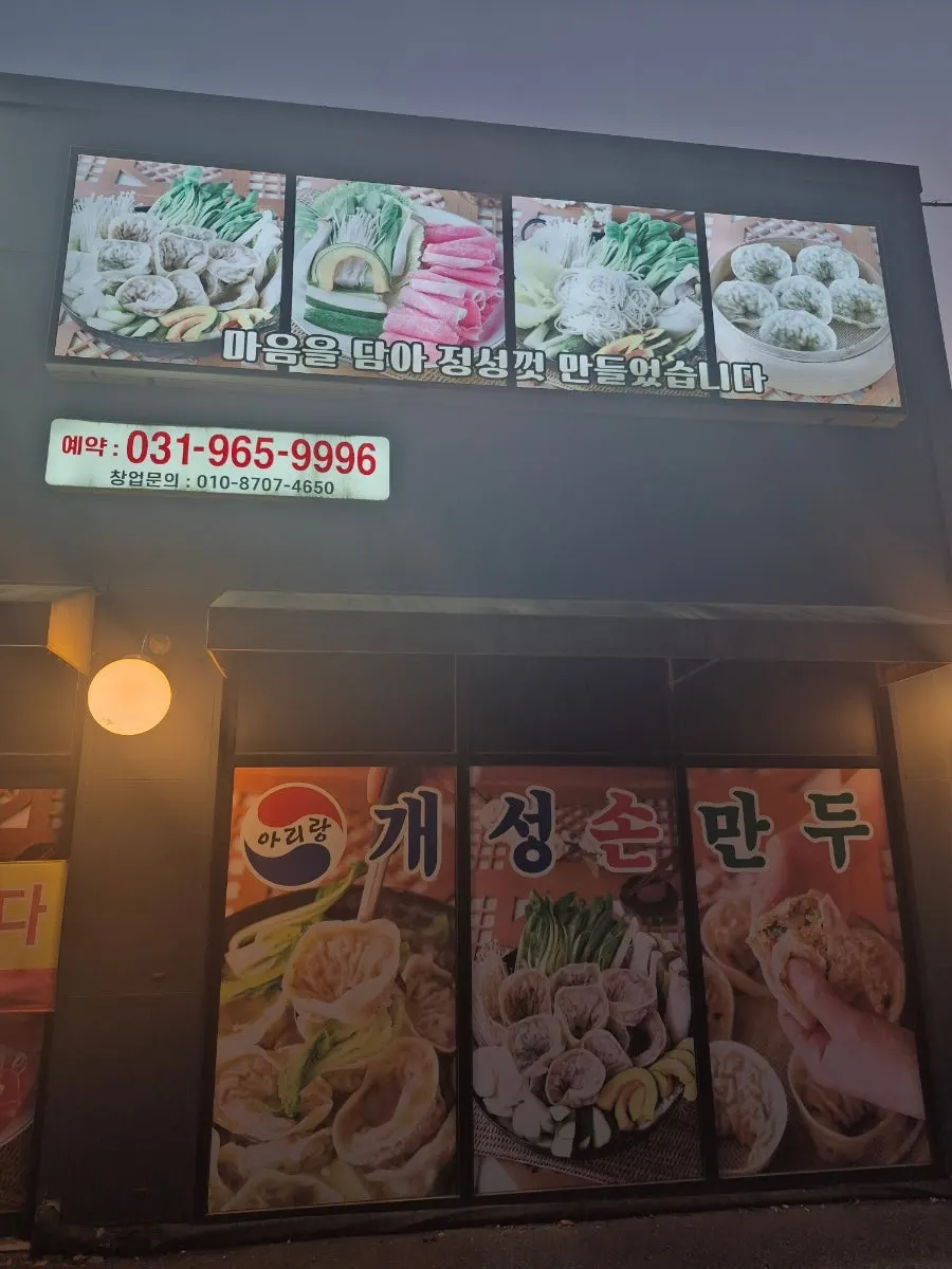 밤에 불 밝힌 아리랑 개성손만두 식사점 간판