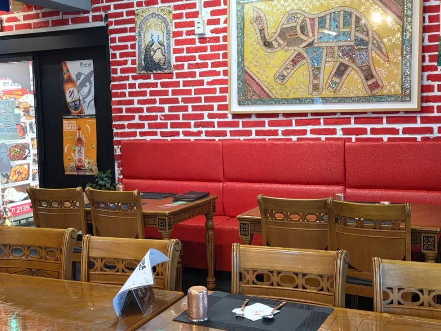 Wall with red brick and a fabric-framed elephant picture