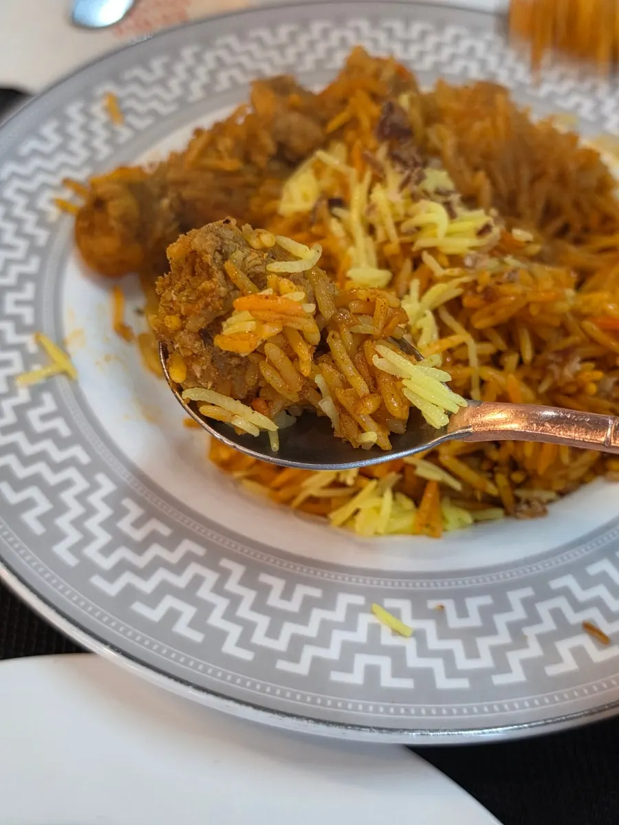 A spoonful of chicken fried rice lifted up