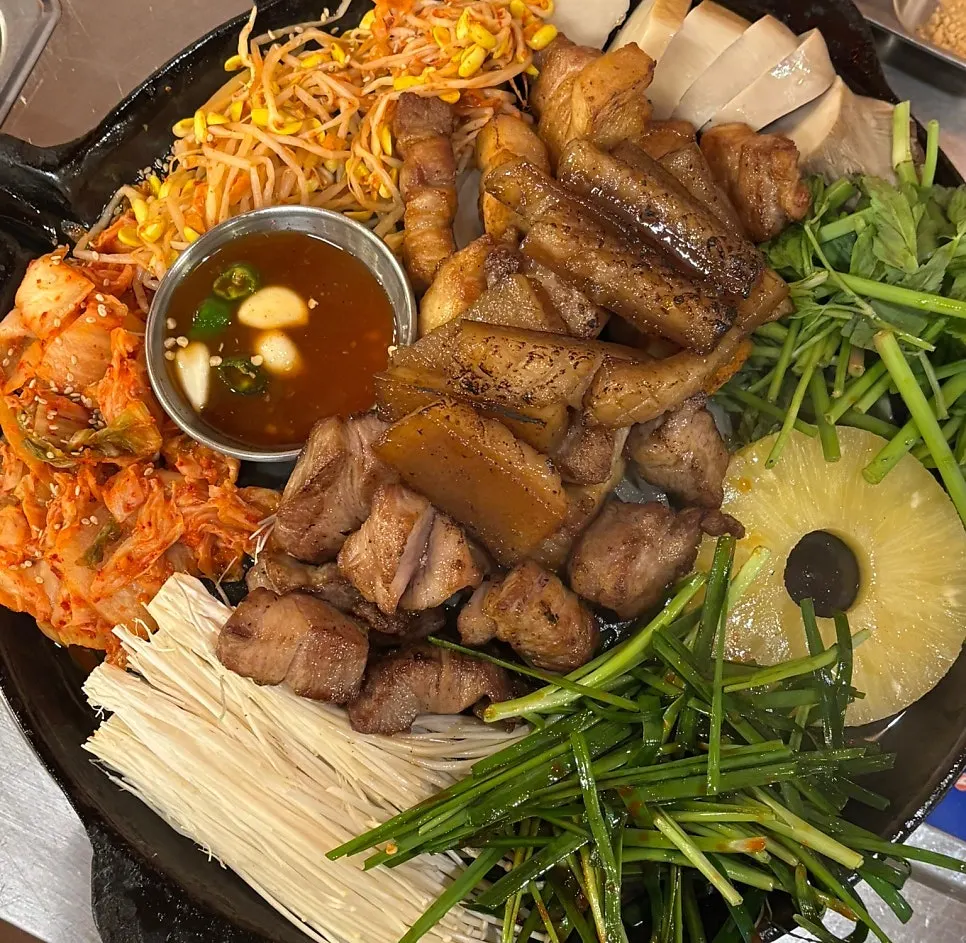 Platter of pre-grilled meat with side ingredients