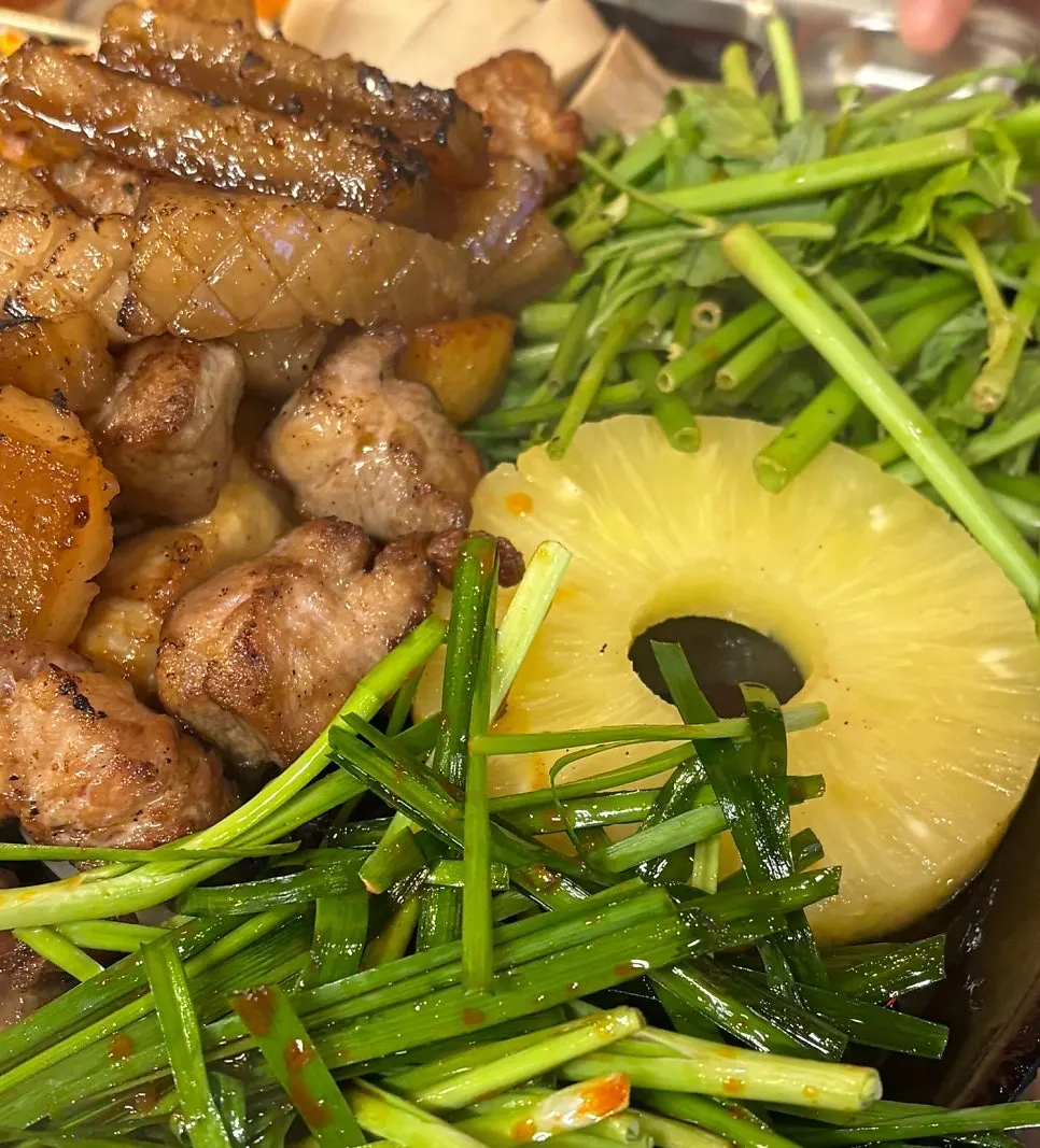 Chives, water parsley and other side vegetables cooking on the grill plate