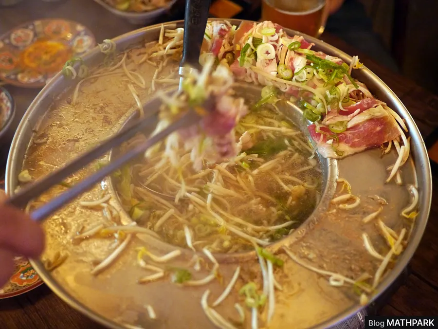 Pot full of bean sprouts and mushrooms for shabu-shabu