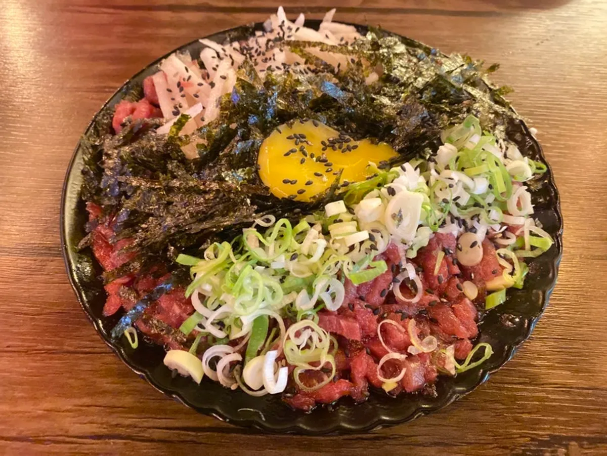 Yukhoe jeongseok topped with egg yolk and seaweed flakes