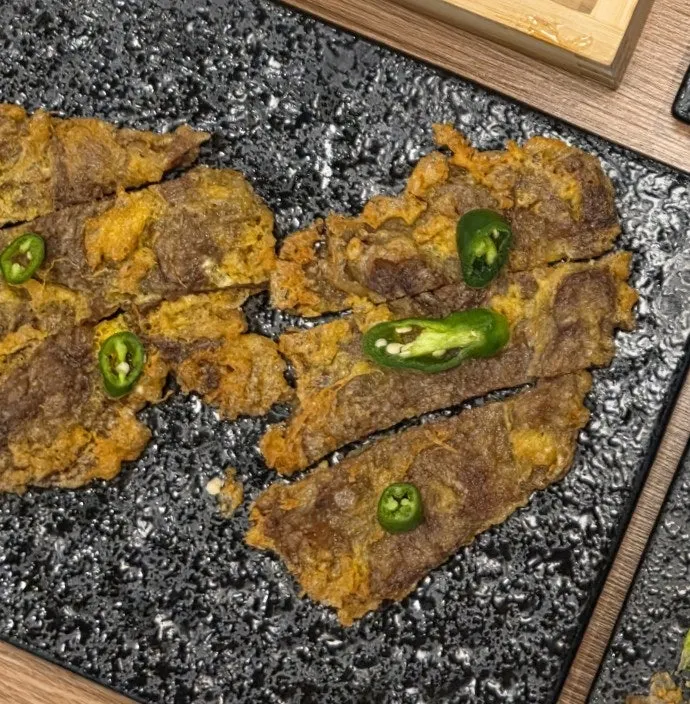 A slice of beef striploin yukjeon