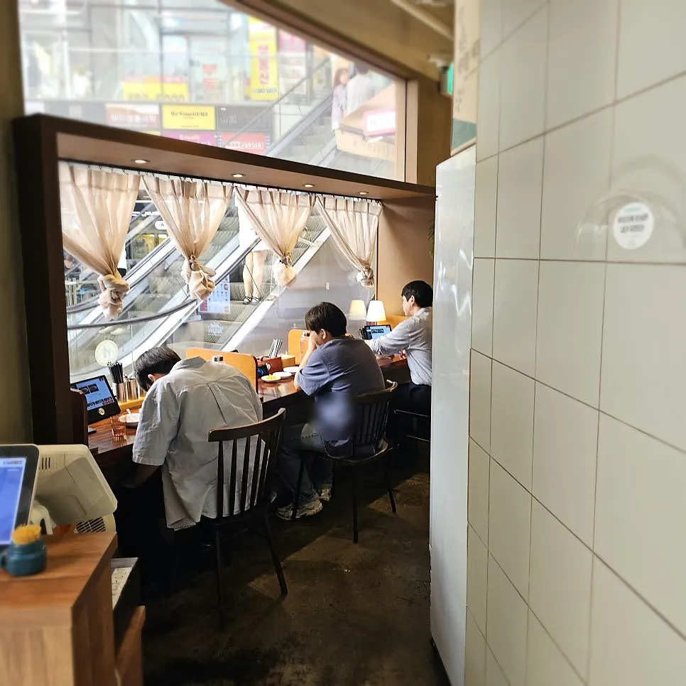 Single seats set up by the window and toward the back of the store