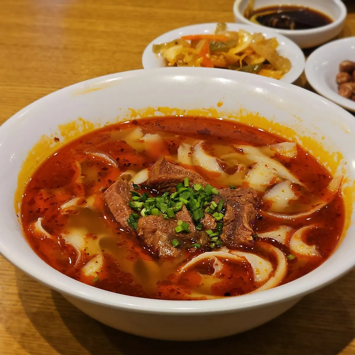 A bowl of beef knife-cut noodles in red broth