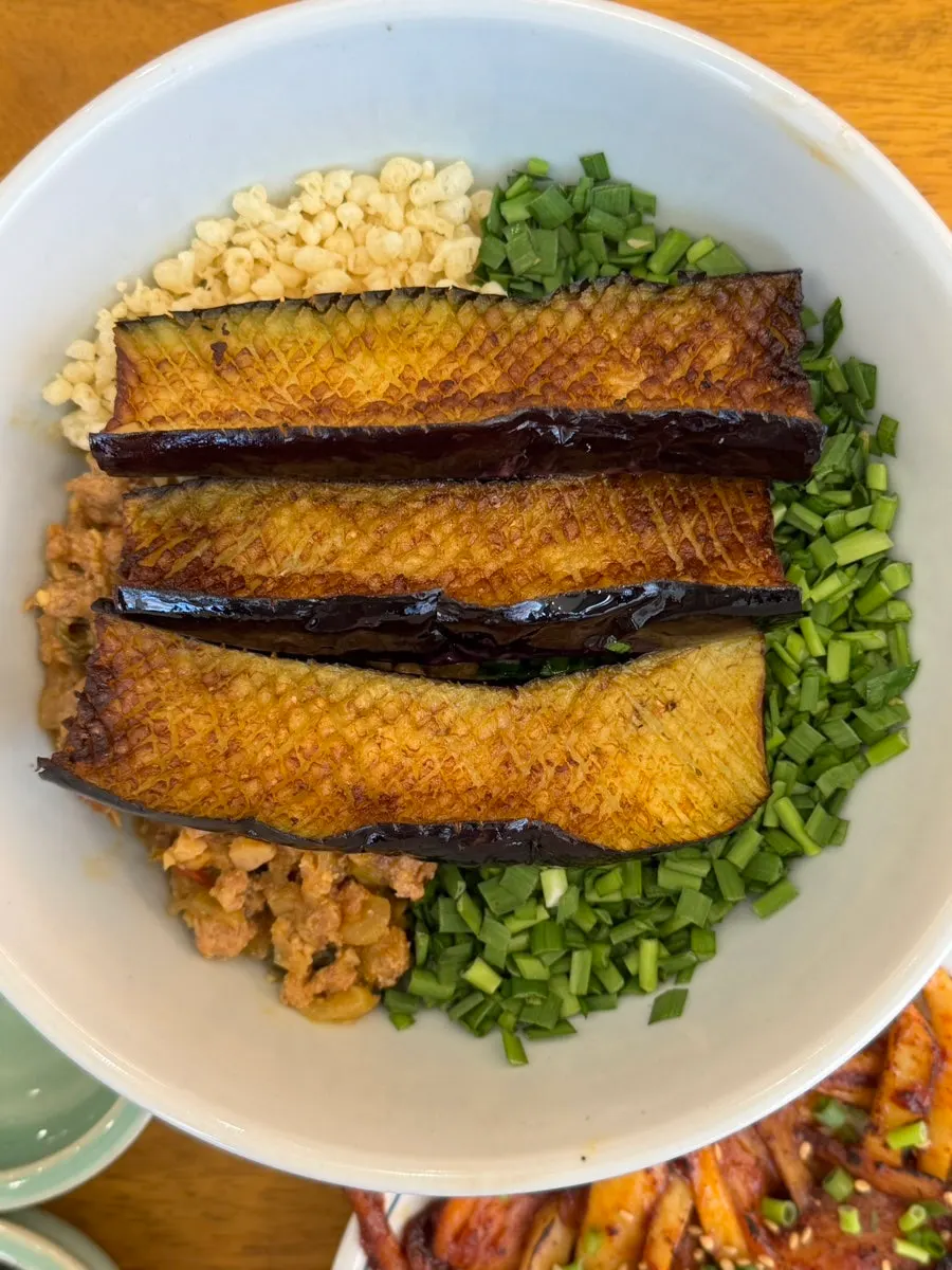 Table setting with eggplant doenjang rice bowl and mackerel gondre rice bowl at Hyangtaek