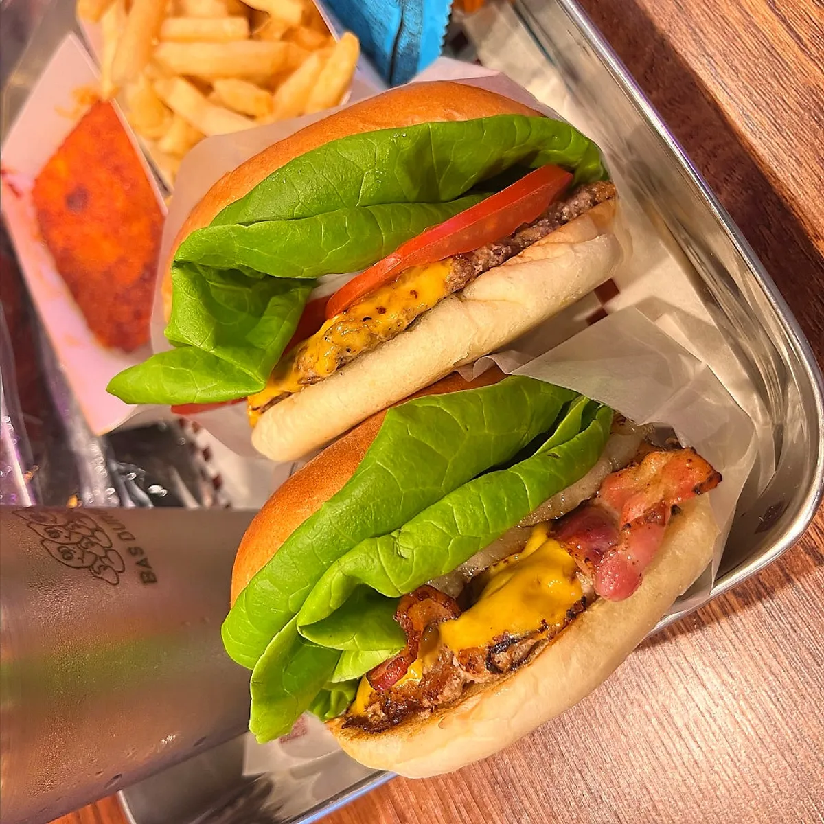 Table spread of Bas Burger set, Hawaiian burger, and mozza cheese bar