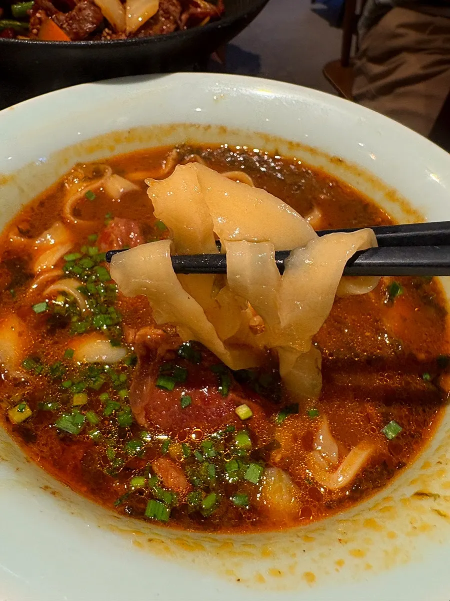 Lifting up the noodles from beef daosakmyeon