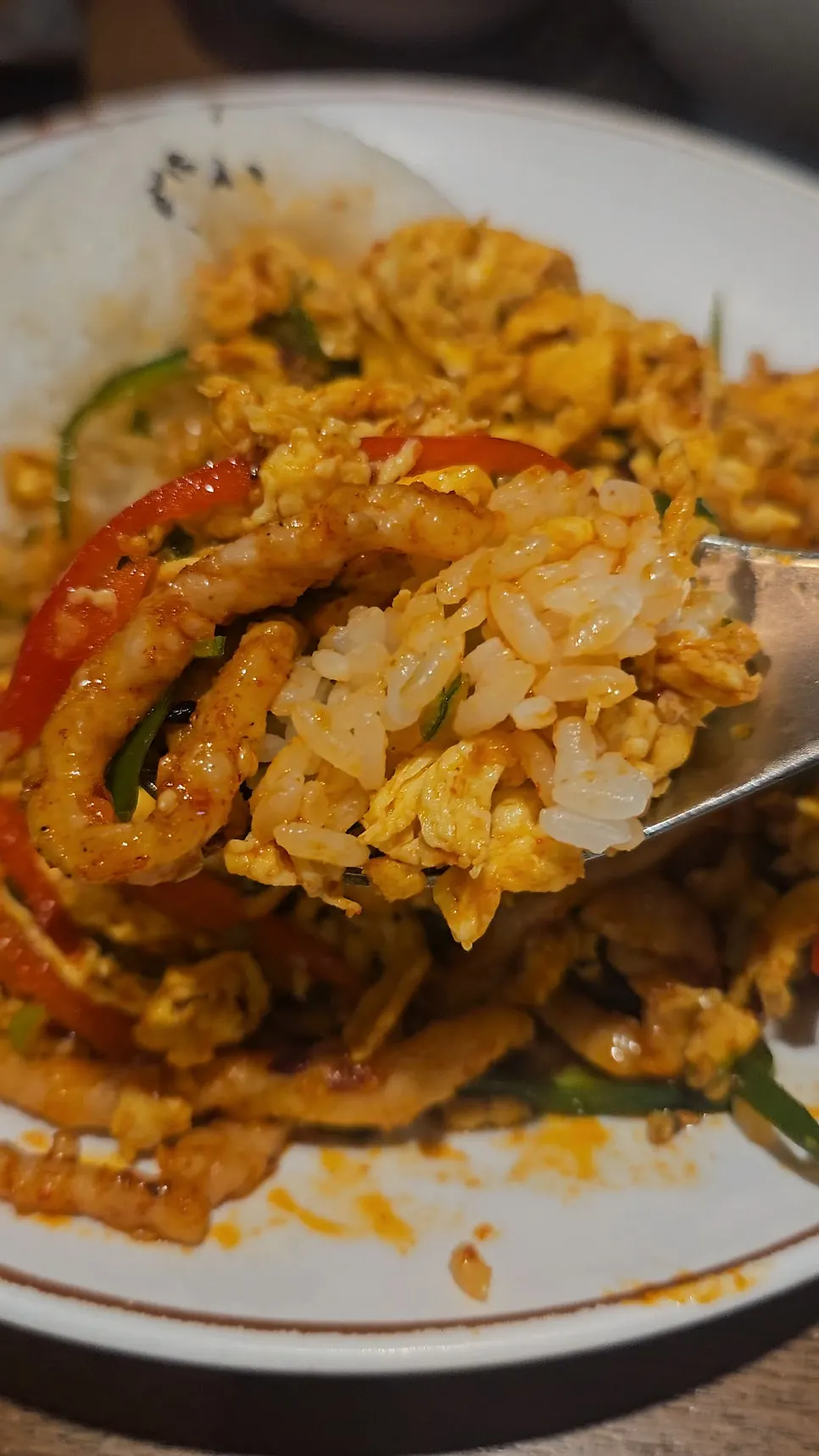 A spoonful of egg fried rice lifted up