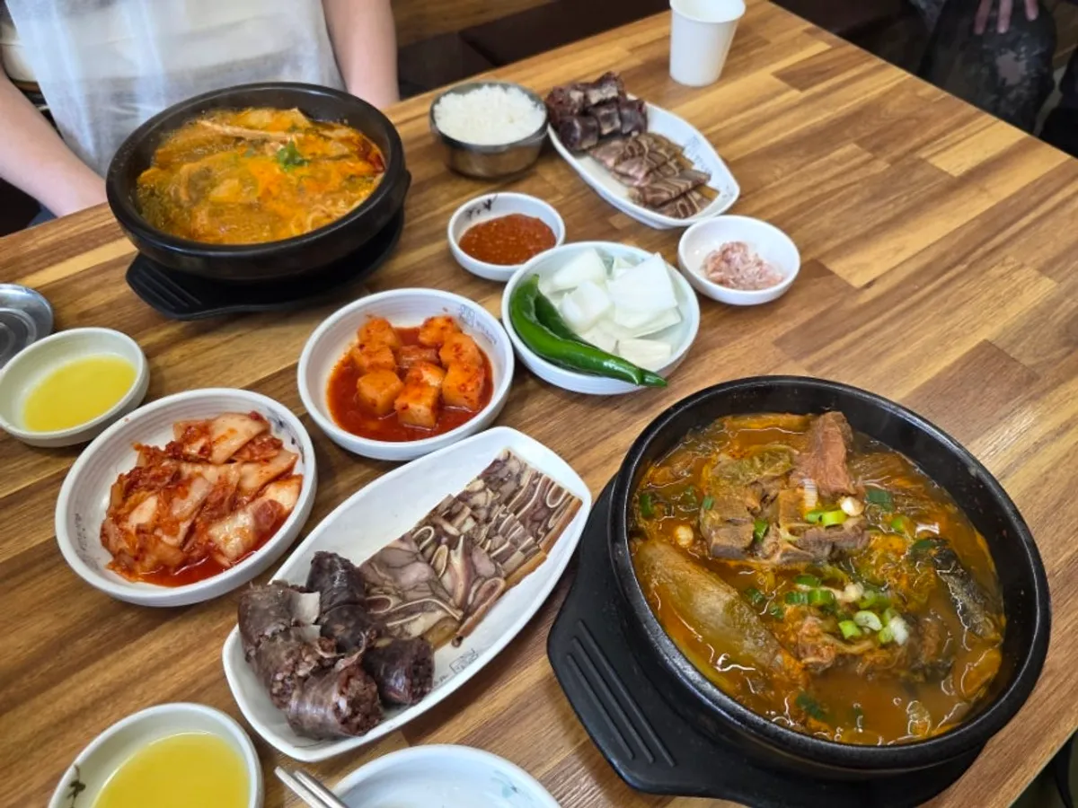 Full table spread of the bone haejang-guk set and beef innards soup set