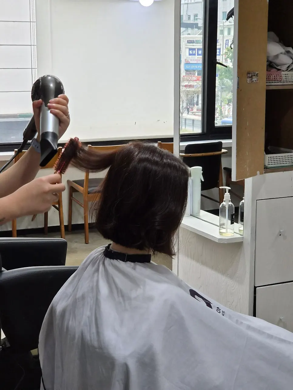 Holding the L'Oréal Professionnel color chart against the hair