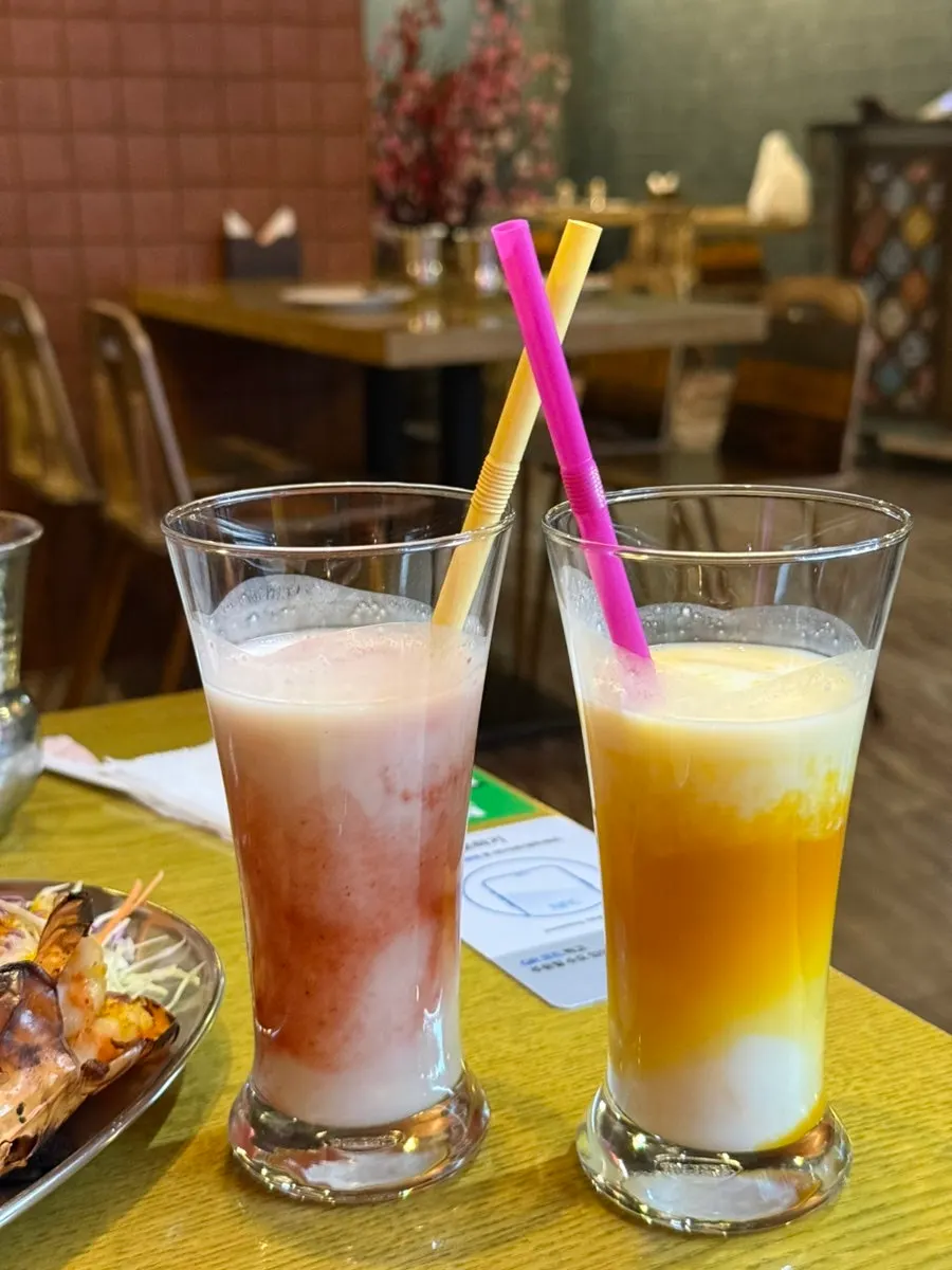 Two glasses of strawberry and mango lassi