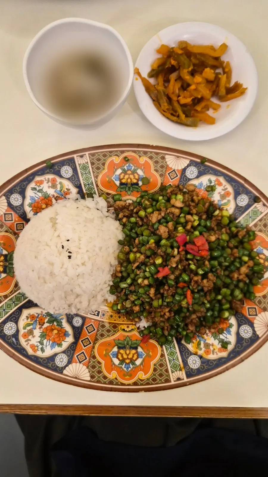 Pork garlic scape rice bowl served on a wide plate